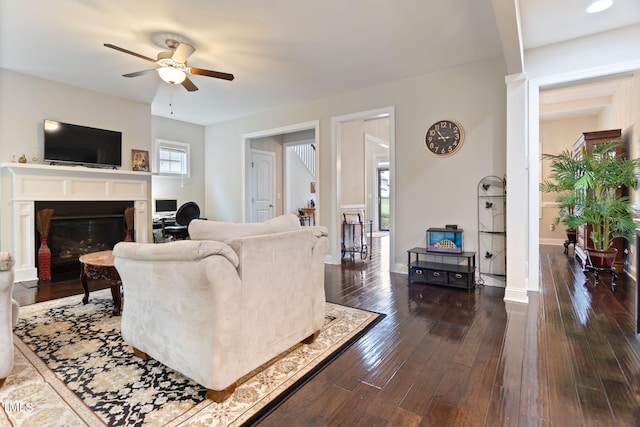 living room with dark hardwood / wood-style flooring and ceiling fan