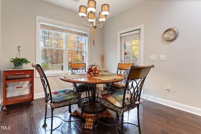 dining area with dark hardwood / wood-style floors and an inviting chandelier