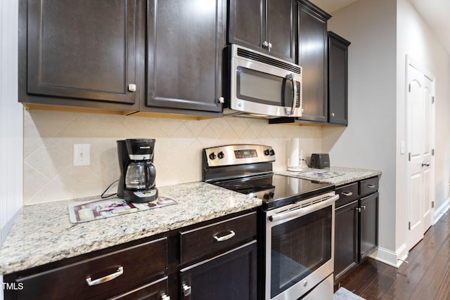 kitchen featuring stainless steel appliances, backsplash, and dark brown cabinetry