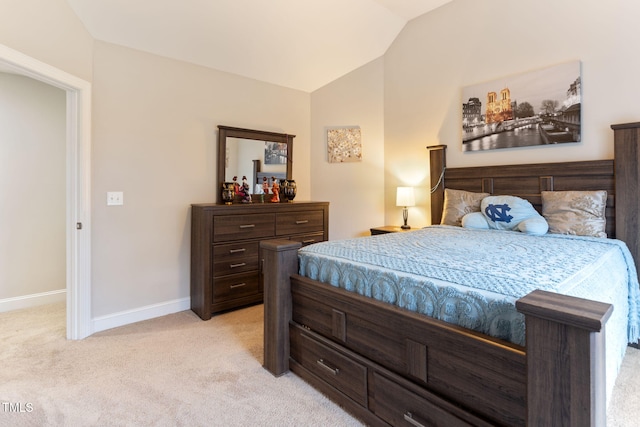 carpeted bedroom with lofted ceiling