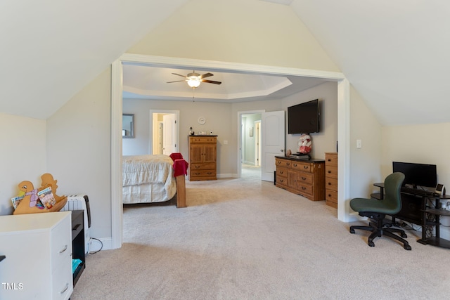 carpeted bedroom with ceiling fan, a raised ceiling, and vaulted ceiling