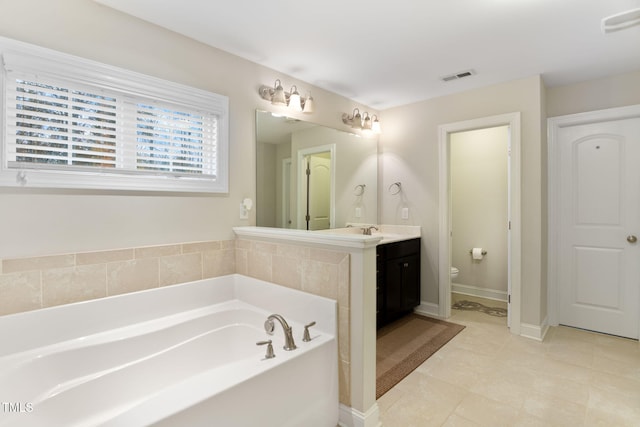 bathroom with vanity, a tub, and toilet