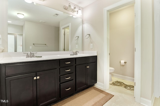 bathroom featuring tile patterned floors, vanity, toilet, and a shower with shower door