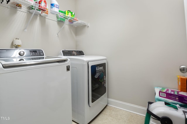 clothes washing area with light tile patterned floors and washing machine and clothes dryer