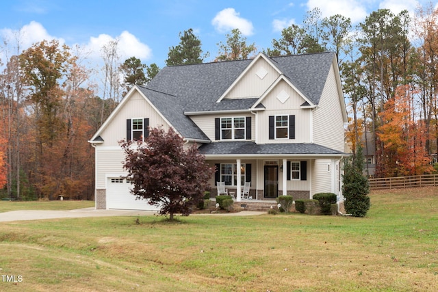 view of front of property featuring a garage, covered porch, and a front lawn