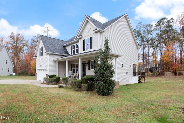 view of front of home with a garage, covered porch, and a front lawn