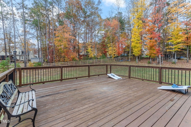 wooden deck featuring a lawn