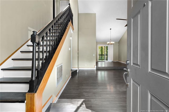 staircase featuring a chandelier, hardwood / wood-style floors, and lofted ceiling