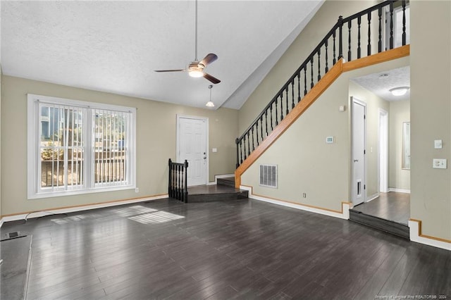 unfurnished living room with hardwood / wood-style floors, ceiling fan, a textured ceiling, and vaulted ceiling