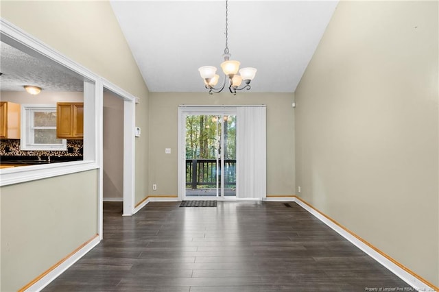 unfurnished dining area with a notable chandelier, dark wood-type flooring, and vaulted ceiling