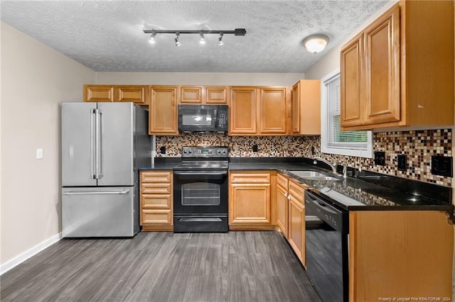 kitchen with sink, dark hardwood / wood-style floors, a textured ceiling, decorative backsplash, and black appliances