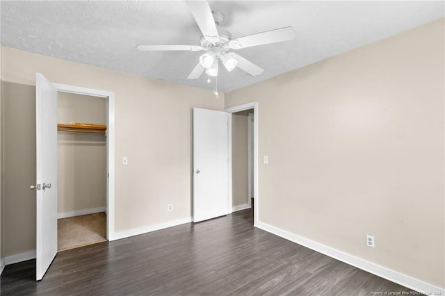 unfurnished bedroom with a textured ceiling, ceiling fan, a closet, and dark hardwood / wood-style floors