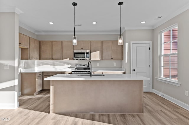 kitchen with stainless steel appliances, hanging light fixtures, a center island with sink, and sink