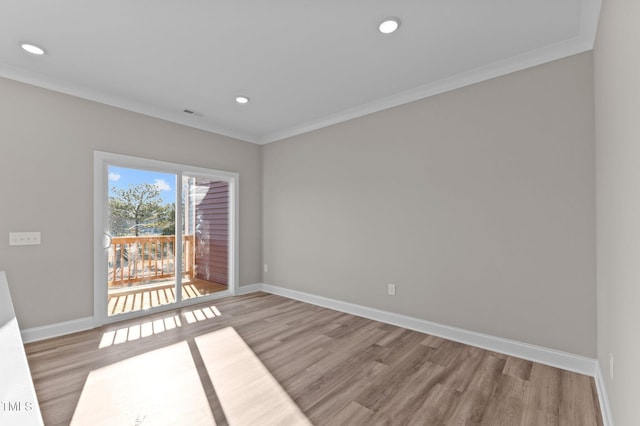 spare room featuring crown molding and light hardwood / wood-style flooring