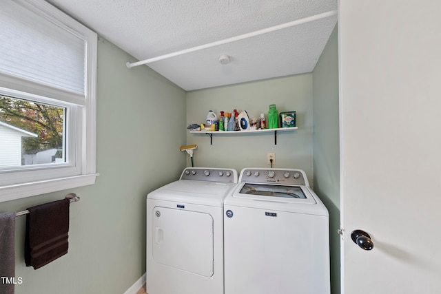 washroom with a textured ceiling and washing machine and dryer