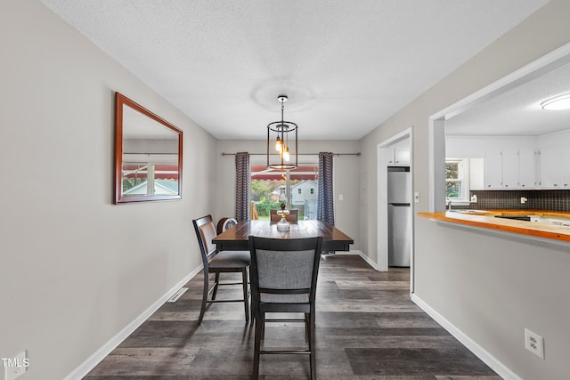 dining area featuring dark hardwood / wood-style flooring and a textured ceiling