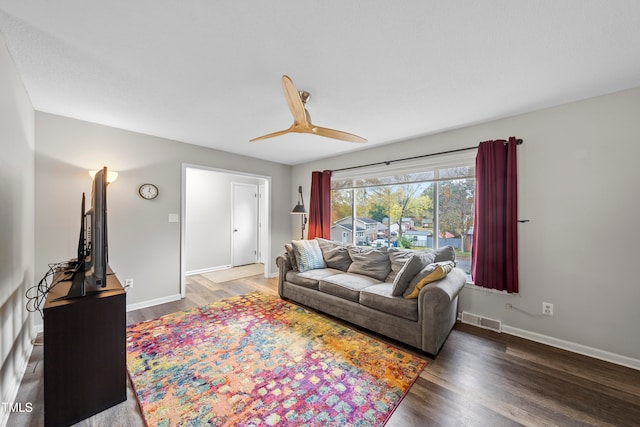 living room with ceiling fan and dark hardwood / wood-style flooring