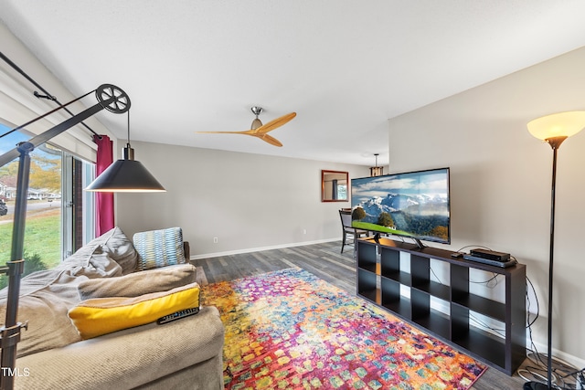 living room featuring ceiling fan and dark wood-type flooring