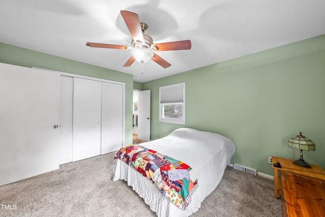 carpeted bedroom with ceiling fan and a closet