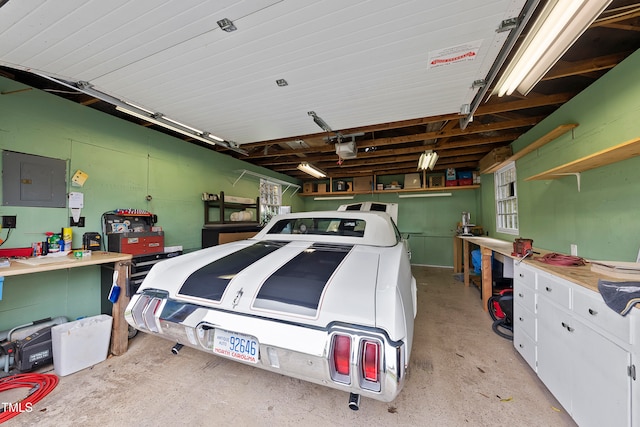 garage with a workshop area, electric panel, and a garage door opener