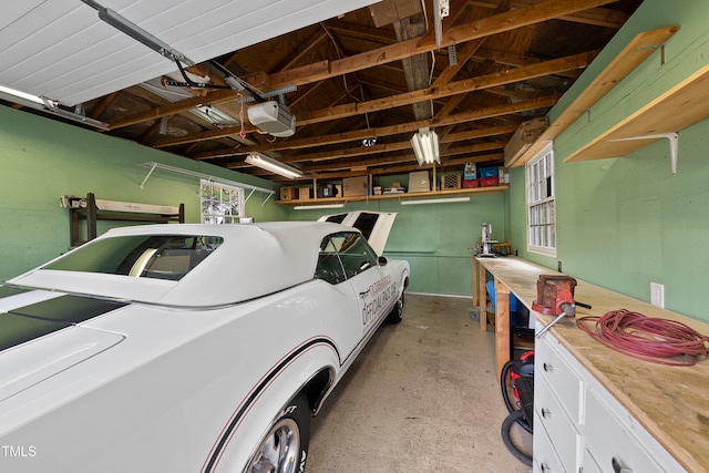 garage with a workshop area and a garage door opener