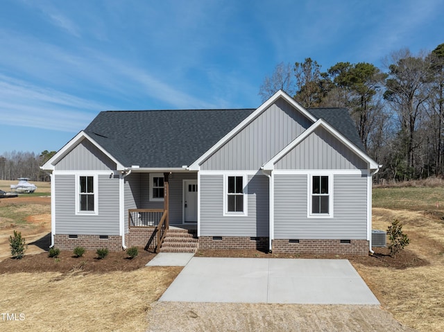 view of front facade with covered porch, central AC, crawl space, and roof with shingles