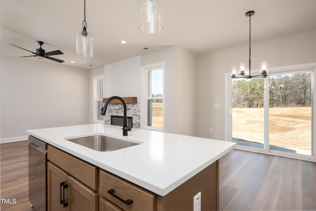 kitchen with pendant lighting, a healthy amount of sunlight, a sink, and dishwasher