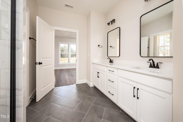 bathroom featuring tile patterned floors, visible vents, a sink, and double vanity