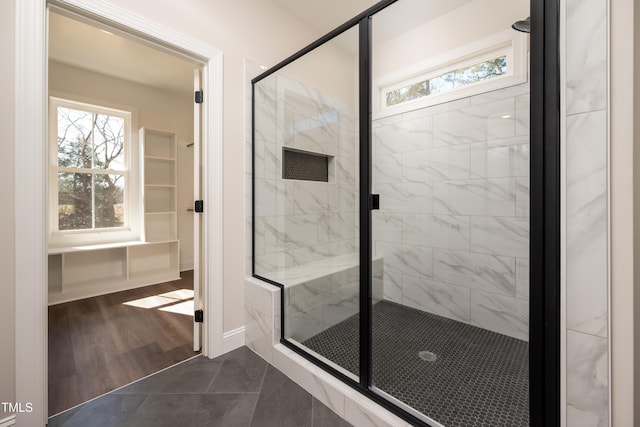 full bathroom with plenty of natural light, a shower stall, baseboards, and wood finished floors