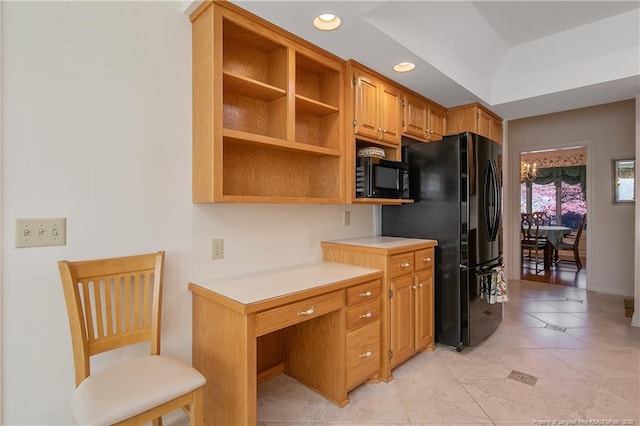 kitchen featuring light tile patterned flooring, a raised ceiling, and black appliances