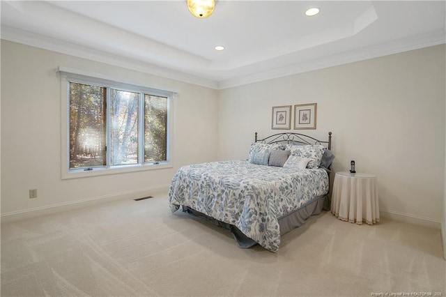 carpeted bedroom featuring a tray ceiling and ornamental molding