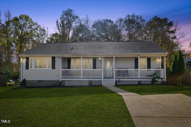 ranch-style house with a porch and a yard