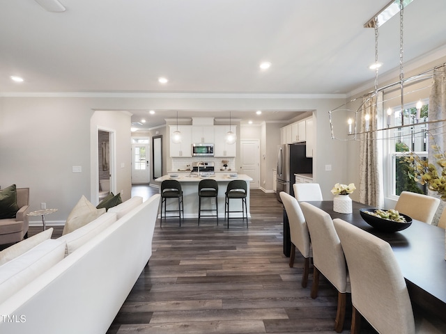 dining space featuring plenty of natural light, dark wood-type flooring, a notable chandelier, and ornamental molding