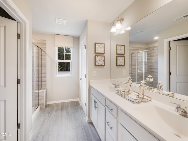 bathroom featuring vanity and a shower with shower door