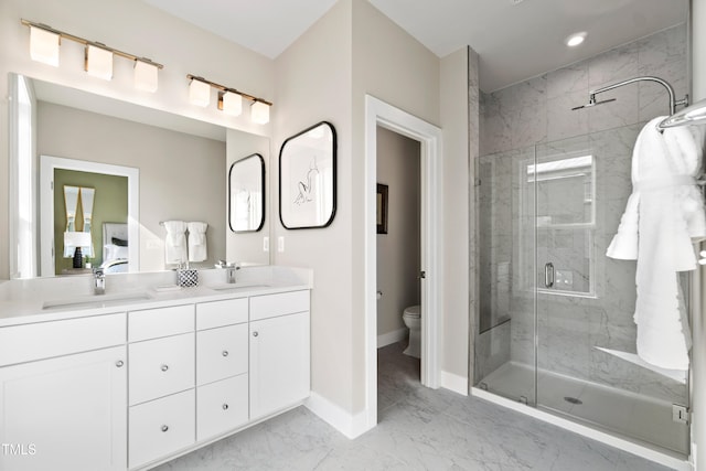 bathroom featuring a shower with door, vanity, and toilet