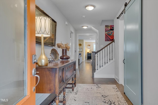 entryway with dark wood-type flooring and a barn door