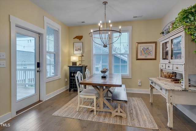 dining area with an inviting chandelier and dark wood-type flooring