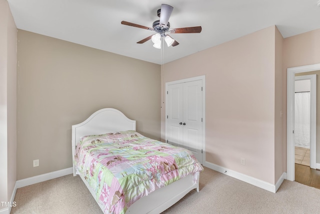 carpeted bedroom featuring ceiling fan and a closet