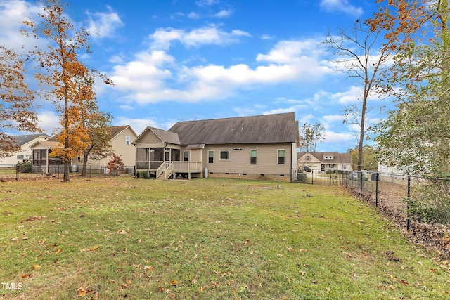 rear view of property featuring a lawn and a sunroom