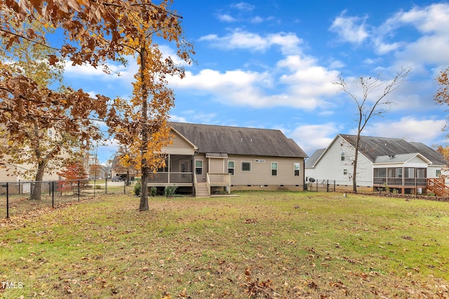 rear view of house with a sunroom and a lawn