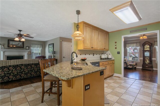 kitchen with kitchen peninsula, a breakfast bar, sink, decorative light fixtures, and light hardwood / wood-style floors