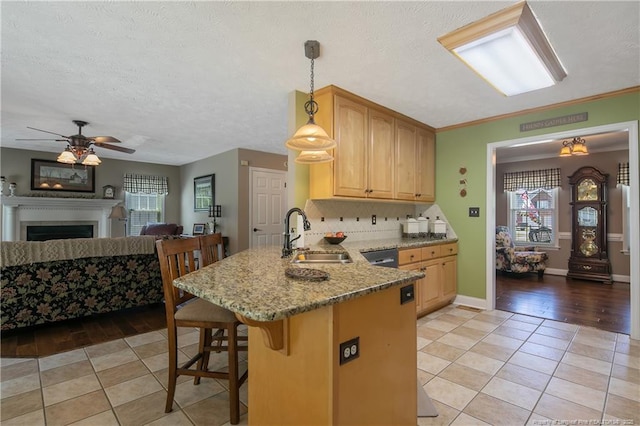 kitchen featuring a kitchen breakfast bar, light tile patterned floors, a sink, open floor plan, and a peninsula