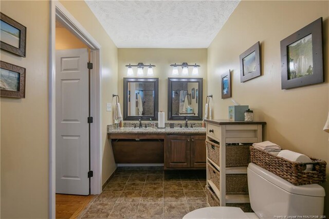 4402 Bluebush Dr, Fayetteville, NC 28312 - full bathroom featuring toilet, a textured ceiling, a sink, and double vanity