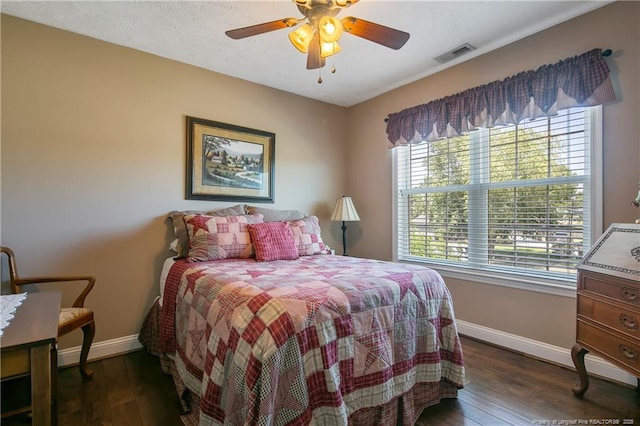 bedroom featuring visible vents, a ceiling fan, dark wood-style floors, and baseboards