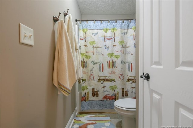 bathroom with curtained shower, toilet, and a textured ceiling