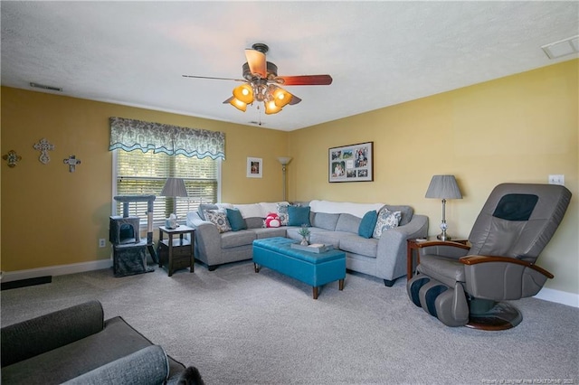 living area with carpet, visible vents, a ceiling fan, and baseboards