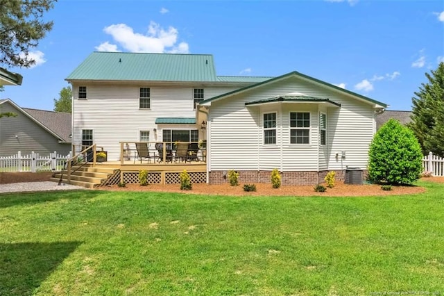 rear view of house with fence, a wooden deck, cooling unit, and a lawn