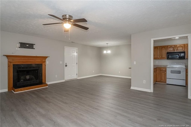 unfurnished living room featuring a textured ceiling, ceiling fan with notable chandelier, and dark wood-type flooring