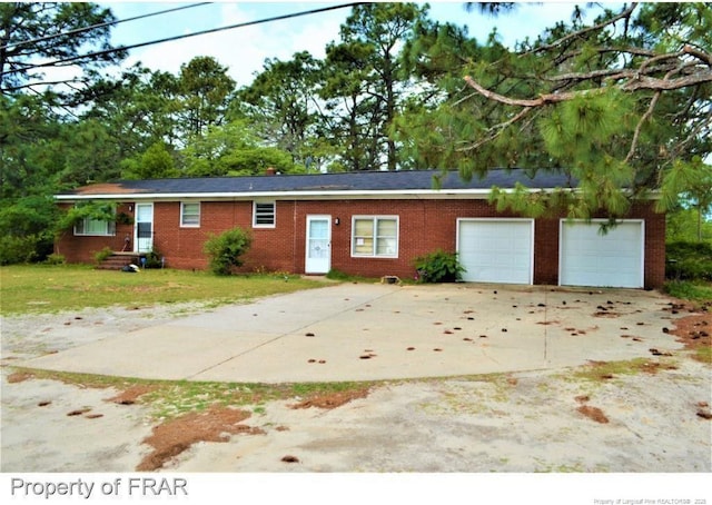 single story home with a garage, driveway, brick siding, and a front lawn