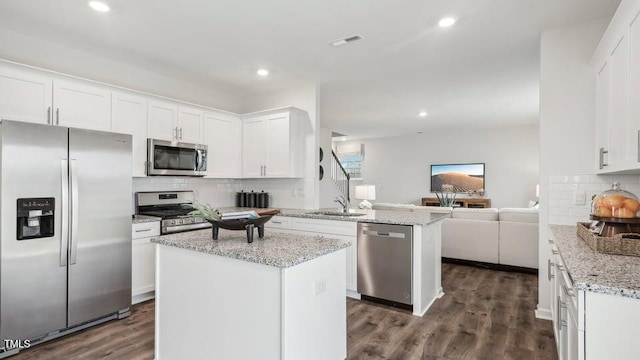 6433 Alfalfa Ln, Wake Forest, NC 27587 - kitchen with appliances with stainless steel finishes, open floor plan, a peninsula, a sink, and white cabinetry
